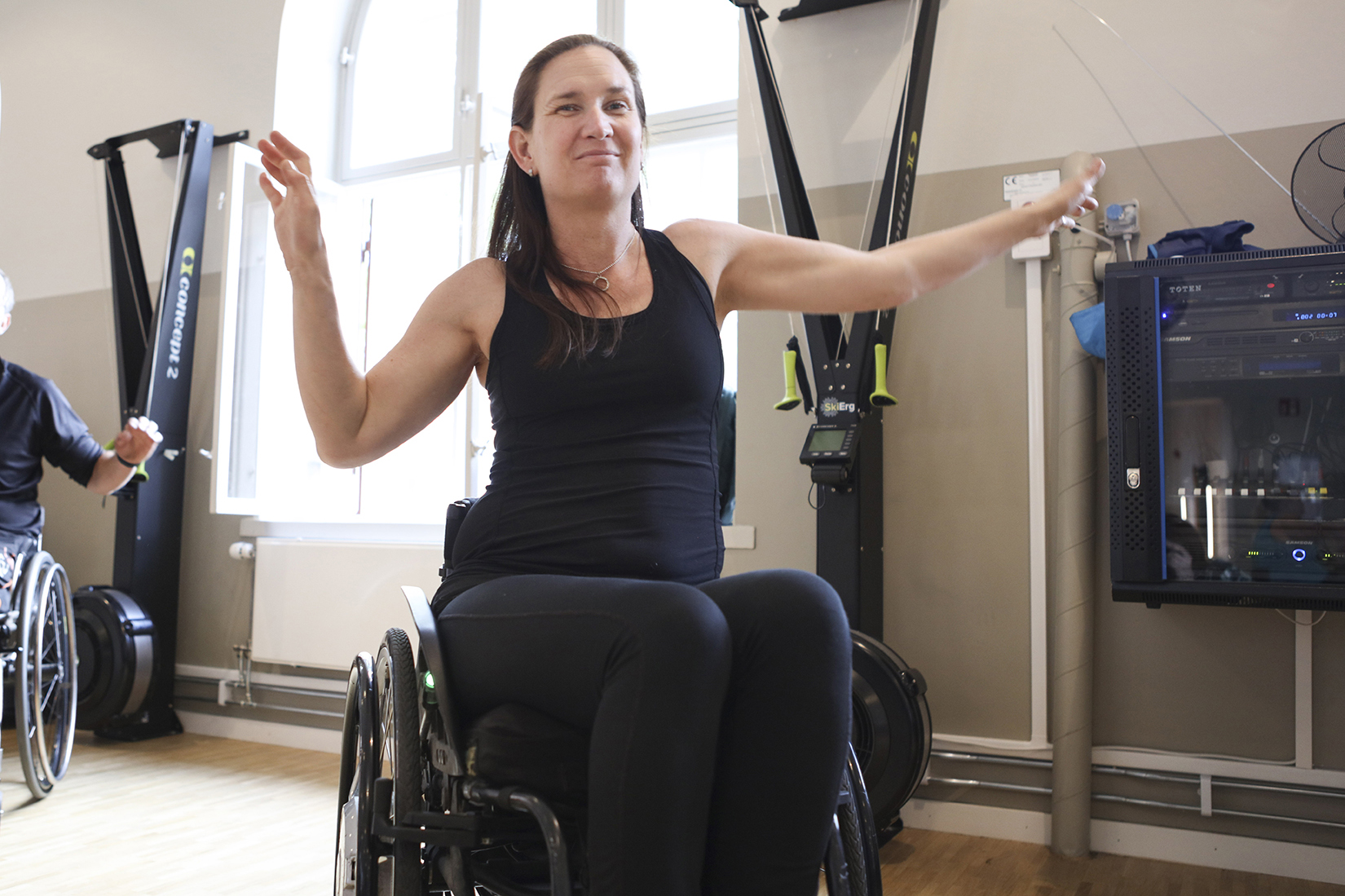 Person i rullstol som tränar på gym. Fotografi.