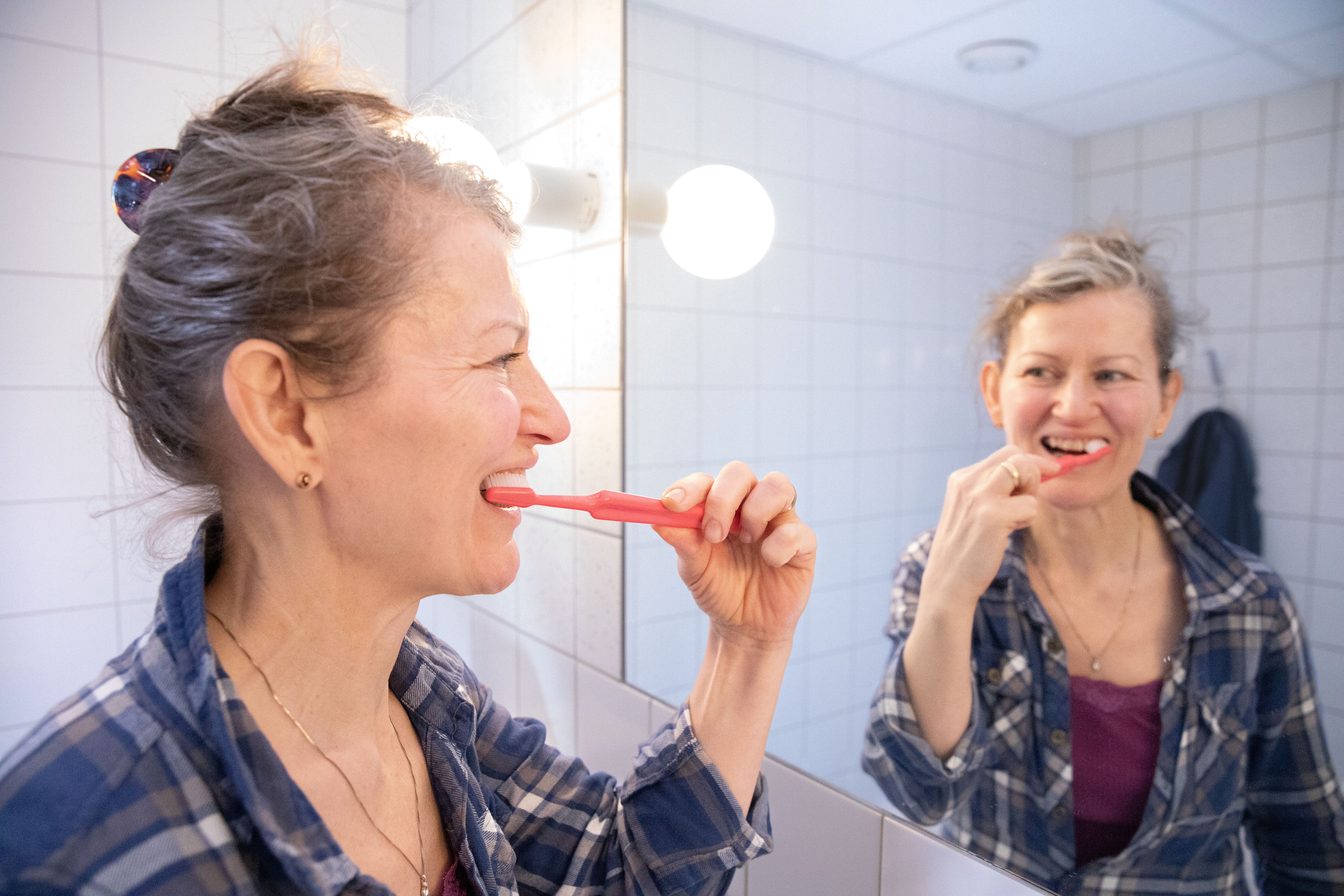En person  borstar tänderna.