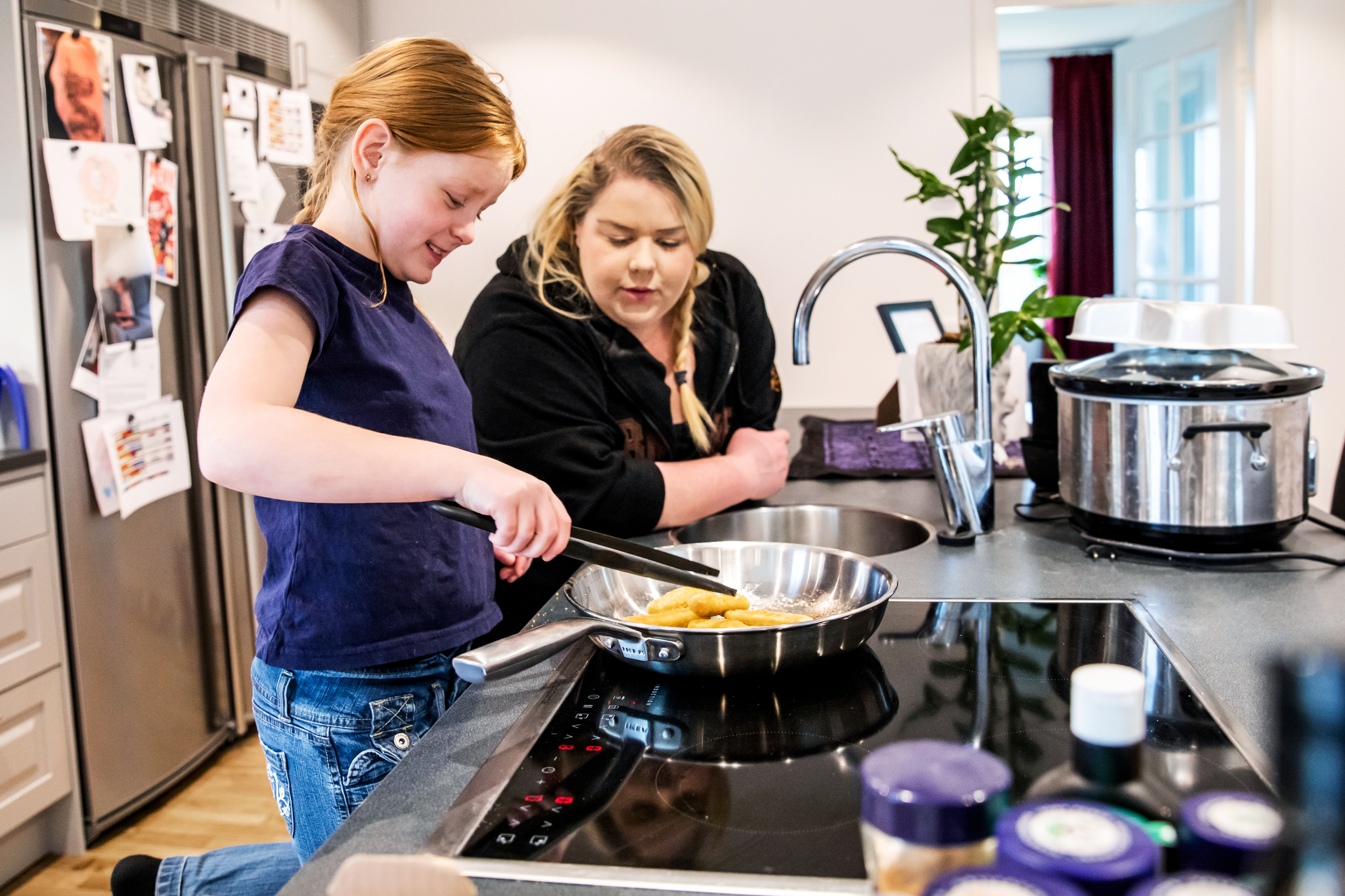 Barn och vuxen hjälps åt att steka mat