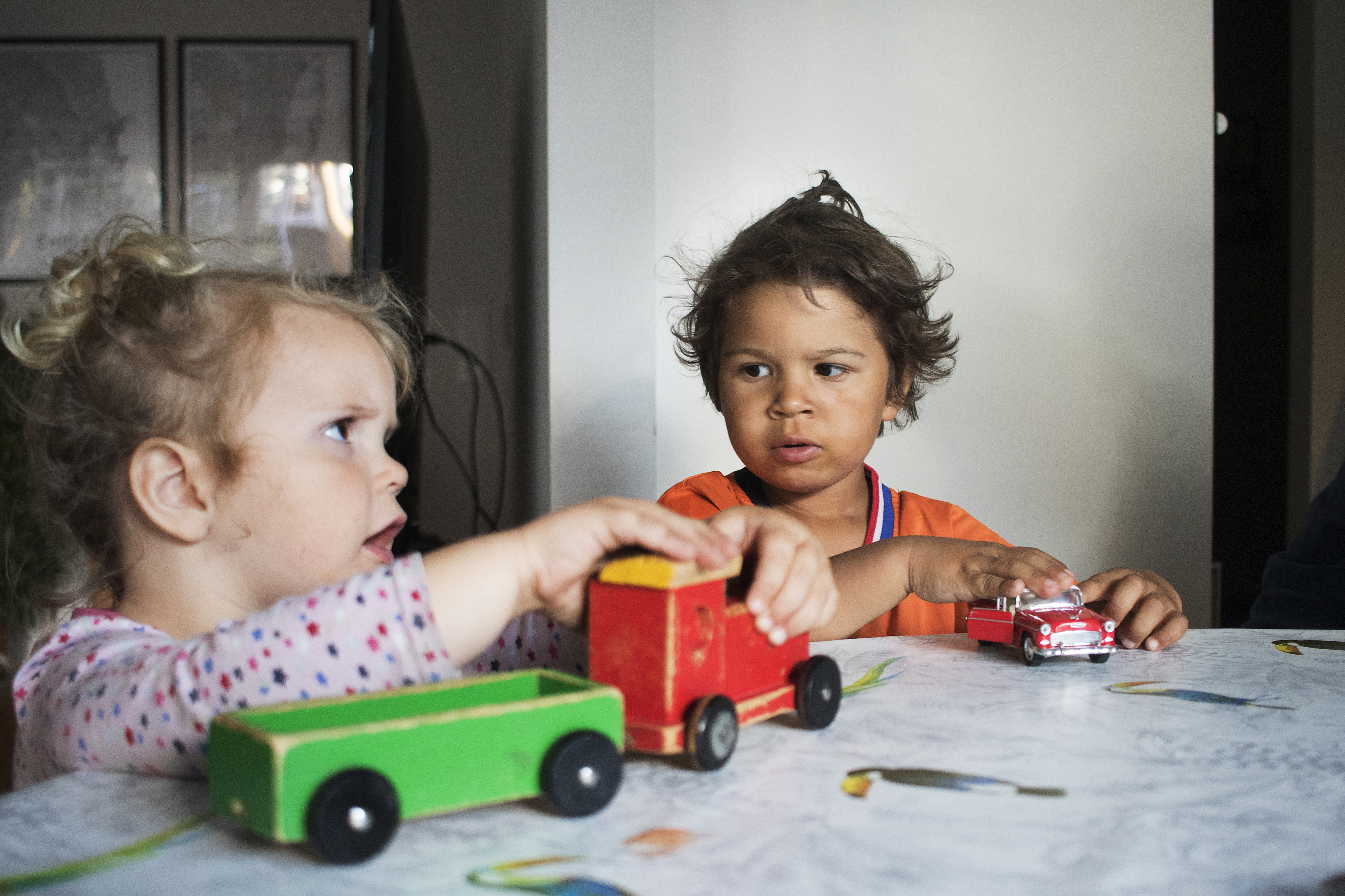 Två barn som leker med tåg och bilar. 
