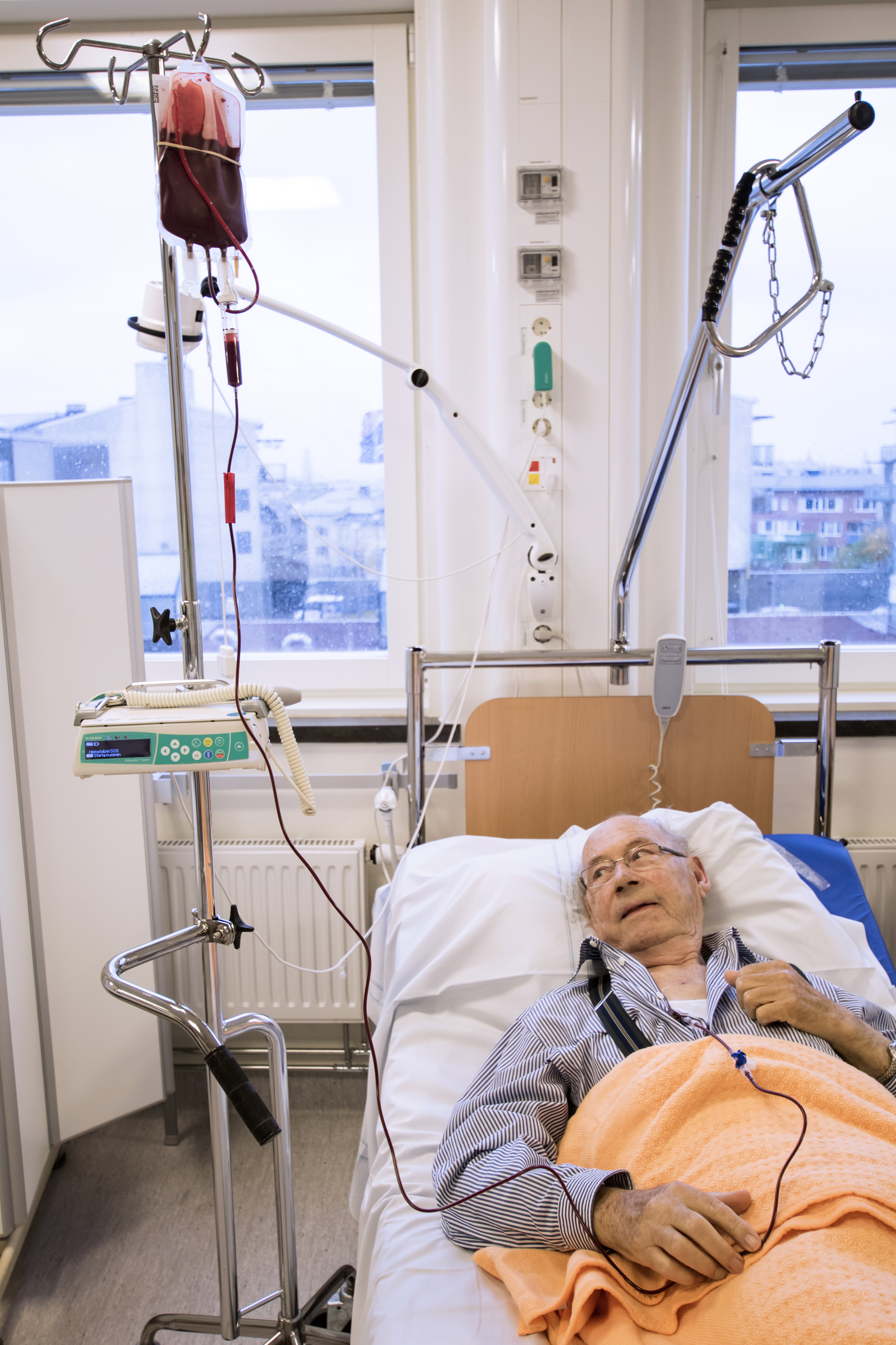 Person i en sjukhussäng som får blodtransfusion