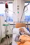 Person i en sjukhussäng som får blodtransfusion