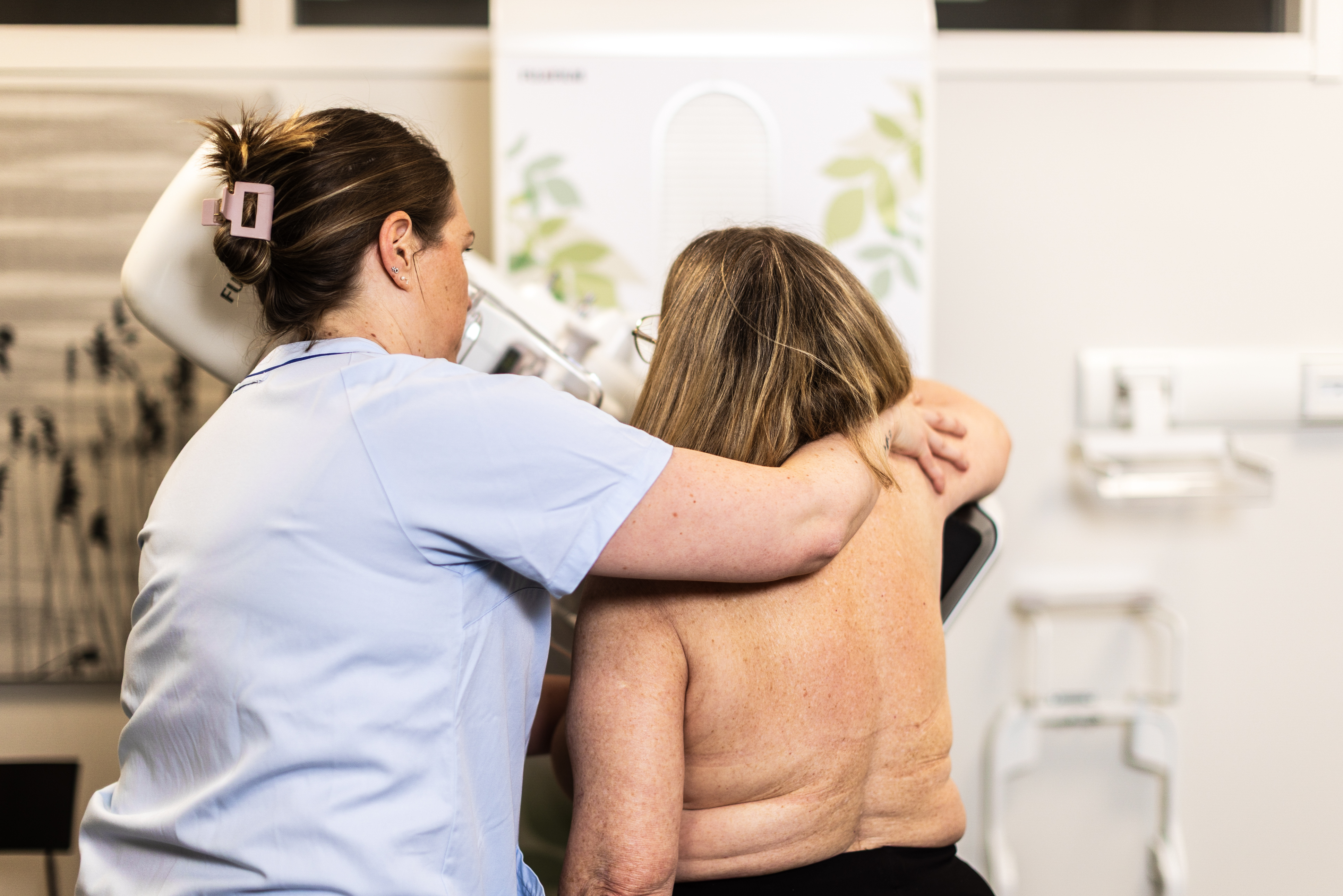 Personalen hjälper till att få rätt placering av personen i mammografimaskinen