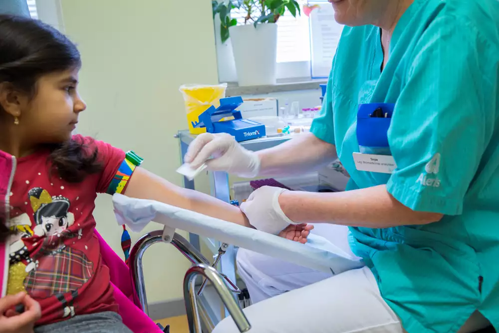 Ett barn får armvecket tvättat av vårdpersonal inför ett blodprov.