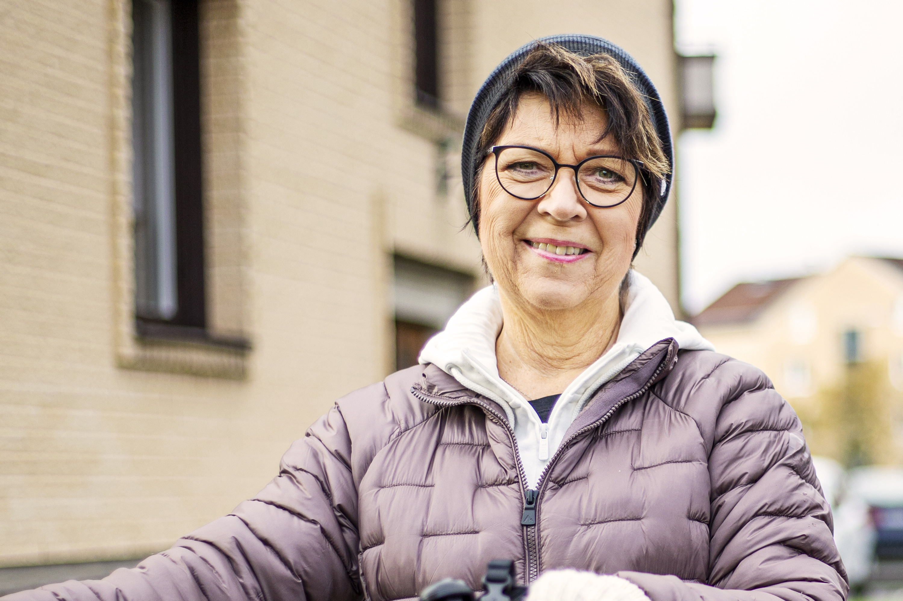 Kvinna står och håller i en cykel