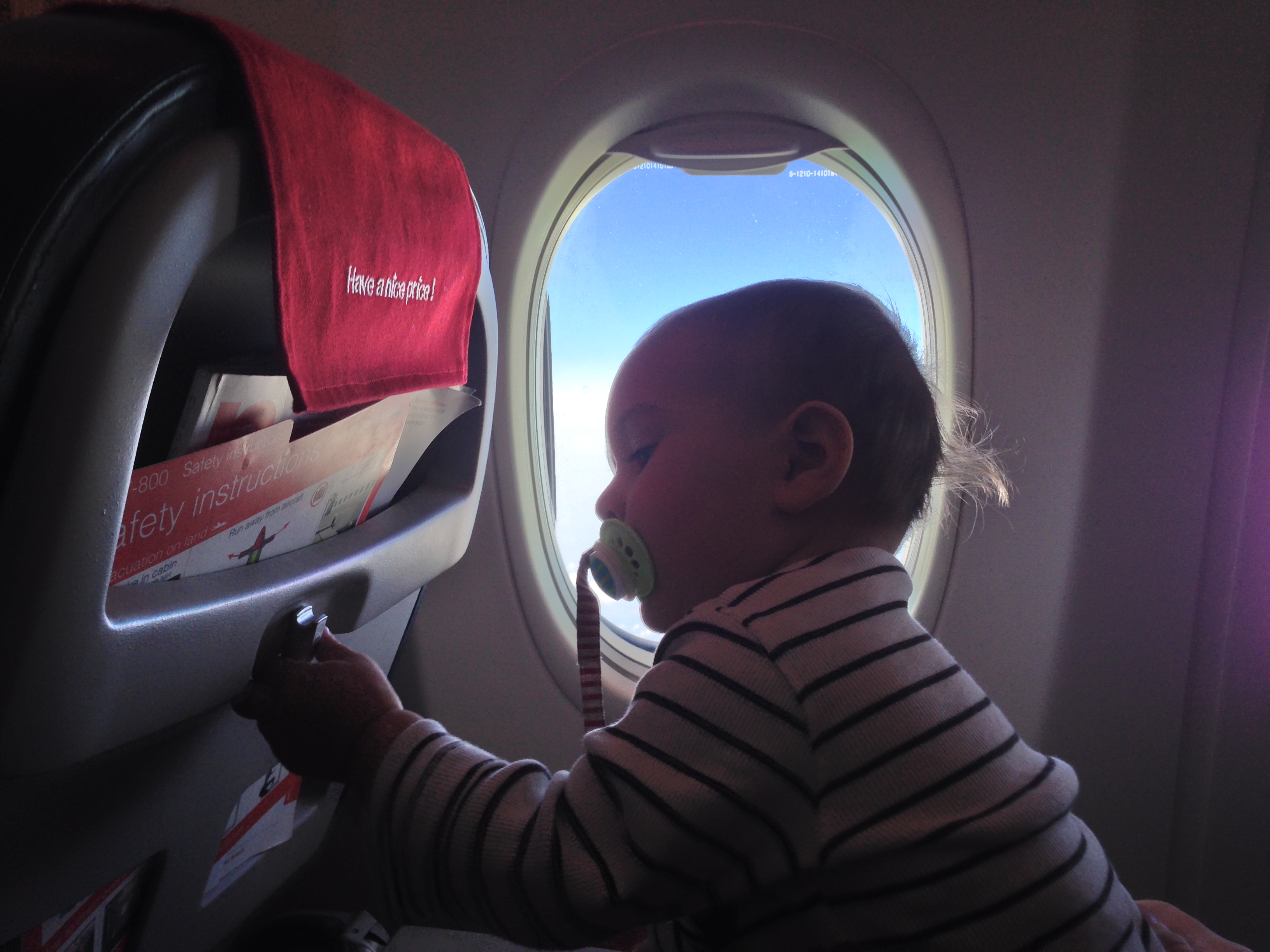 Ett litet barn som sitter i ett flygplan.