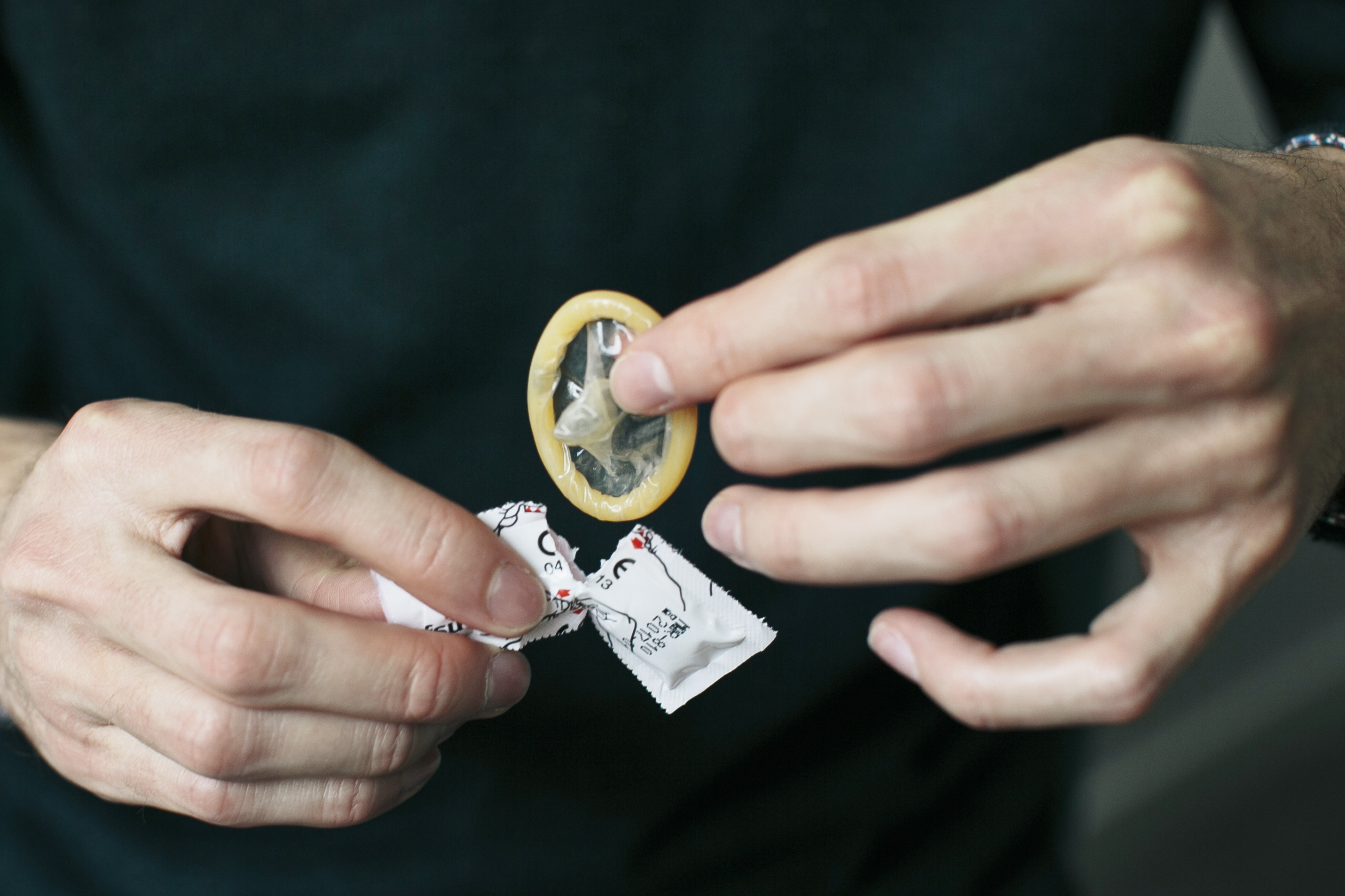 Person som öppnar en kondom