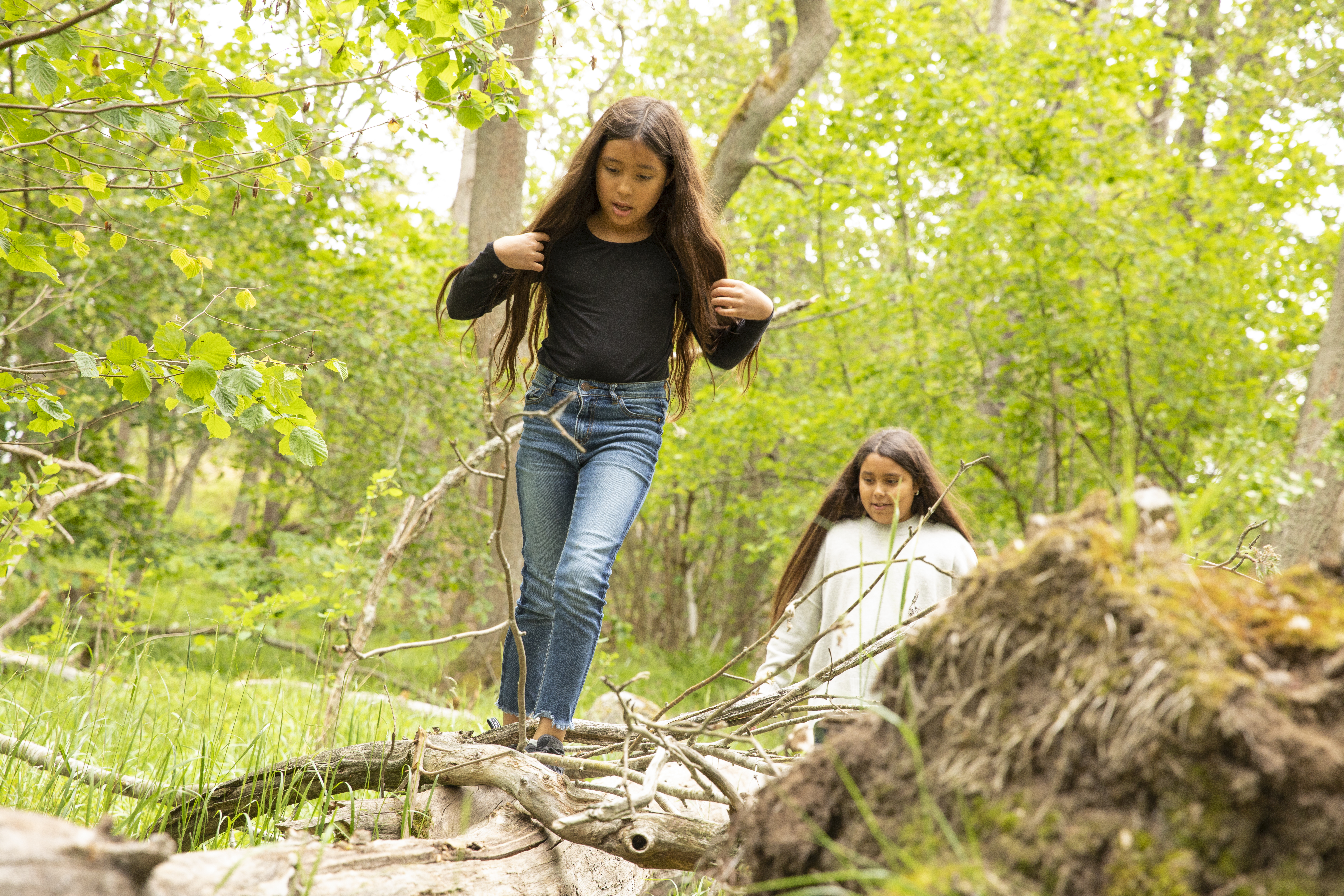 Två barn som rör sig i skogen.