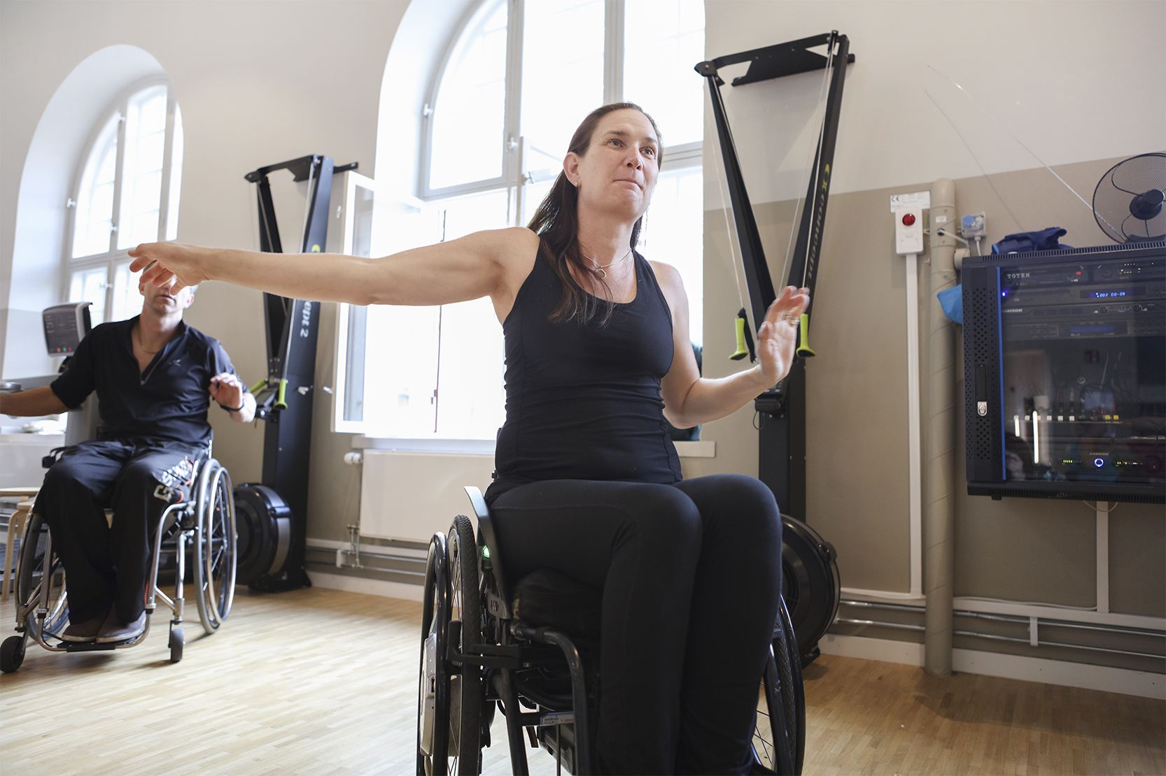 Person i rullstol som tränar på gym. Fotografi.