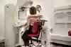Person som sitter och gör mammografiundersökning. 