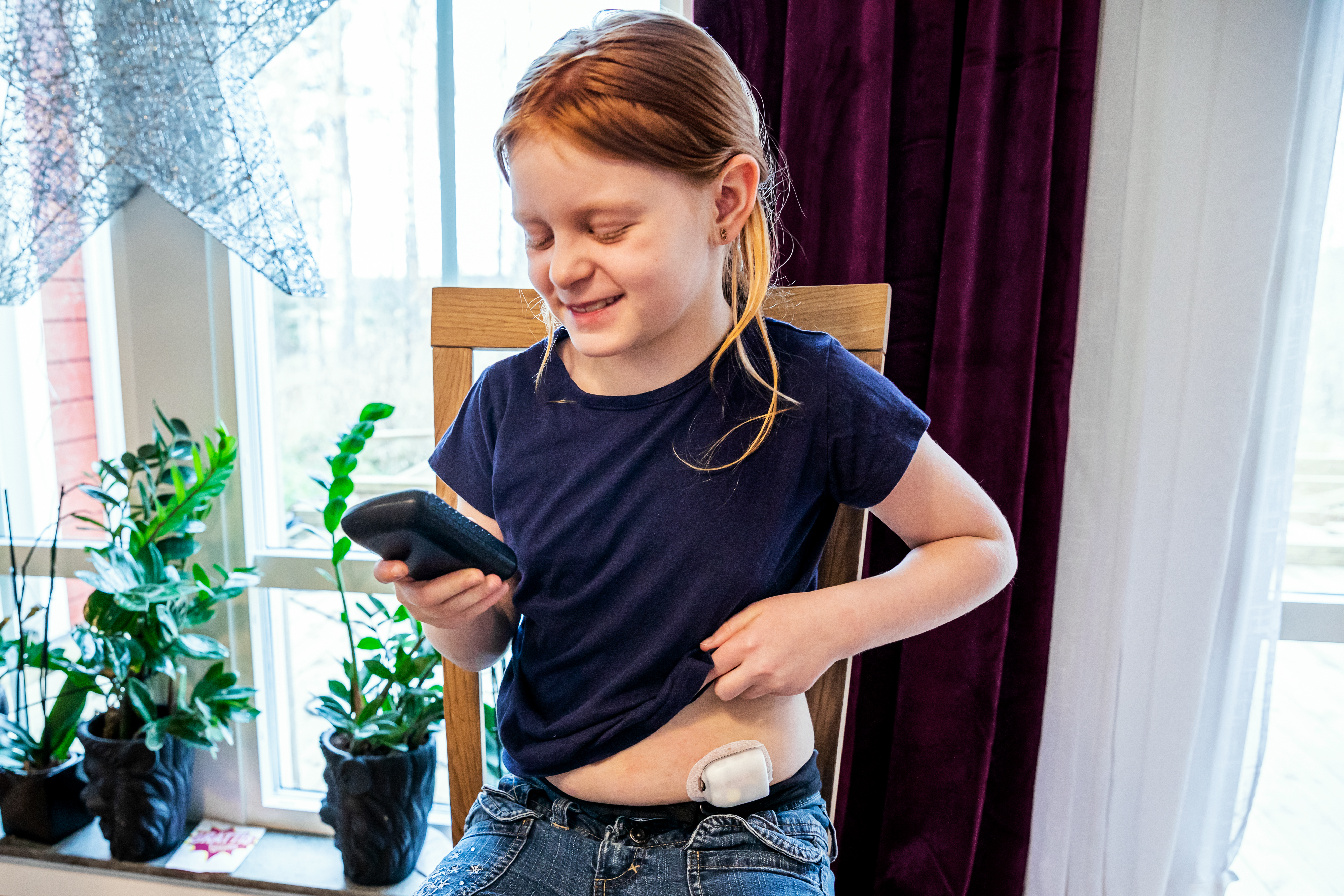 Barn som visar sin insulinpump. fotografi.