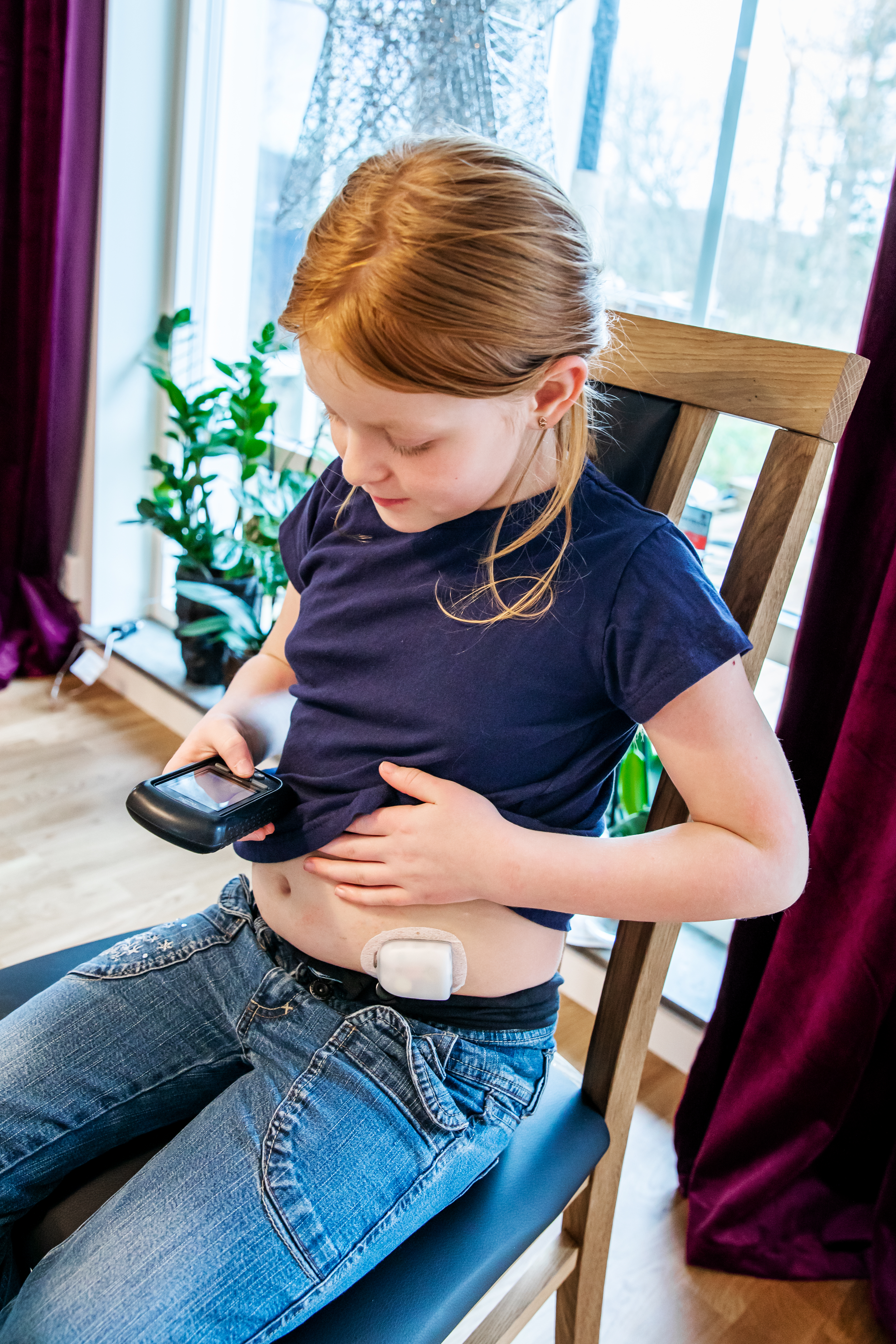 Ett barn med insulinpump i form av en kapsel som styrs  med en fjärrkontroll.