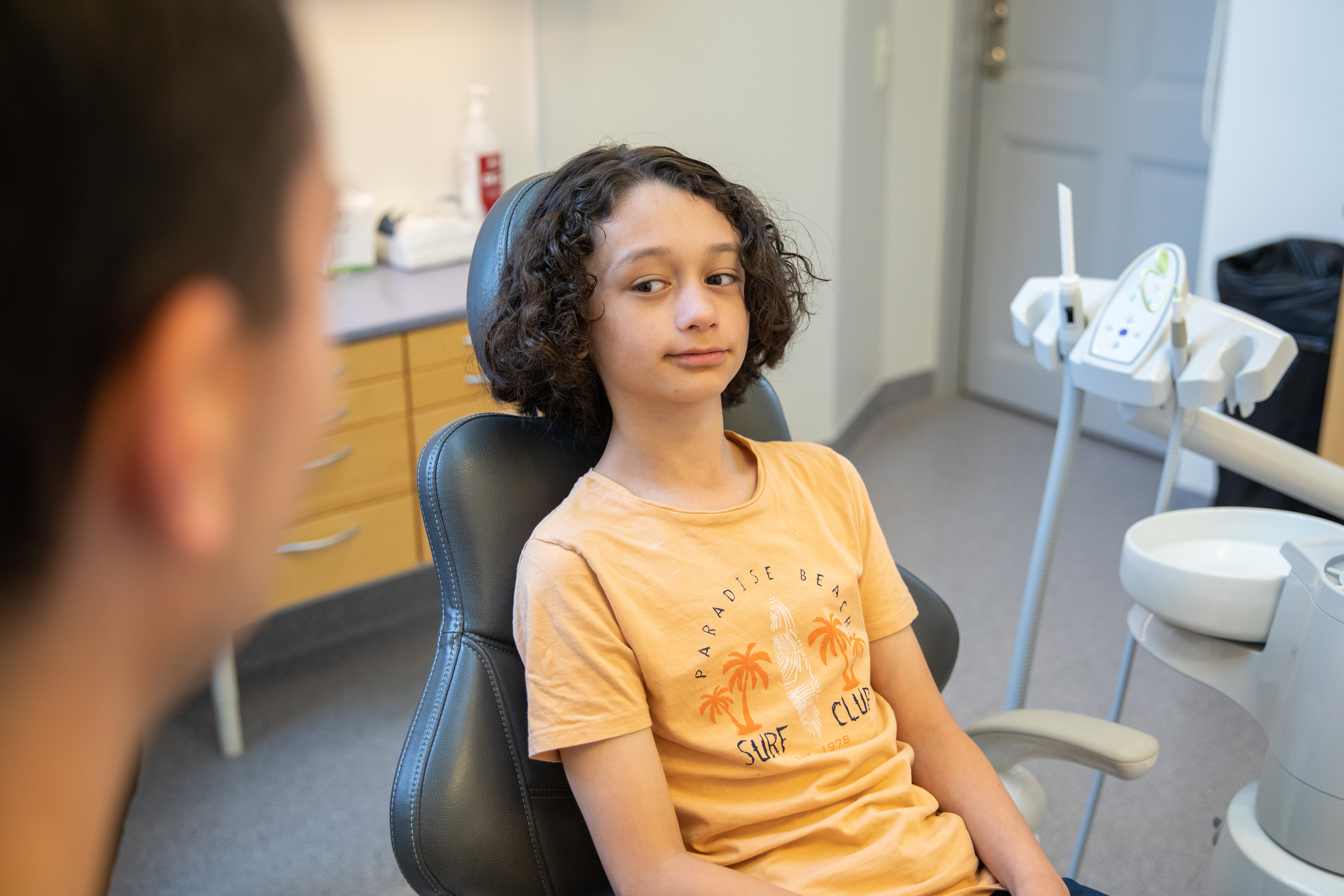 Ett barn som sitter i en undersökningsstol på en tandvårdsmottagning.