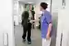 En person hälsar på vårdpersonal med en handskakning.