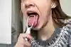En tjej skrapar sin tunga. 