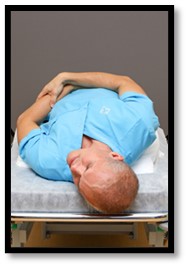 Person ligger ner med huvudet utanför sängen.