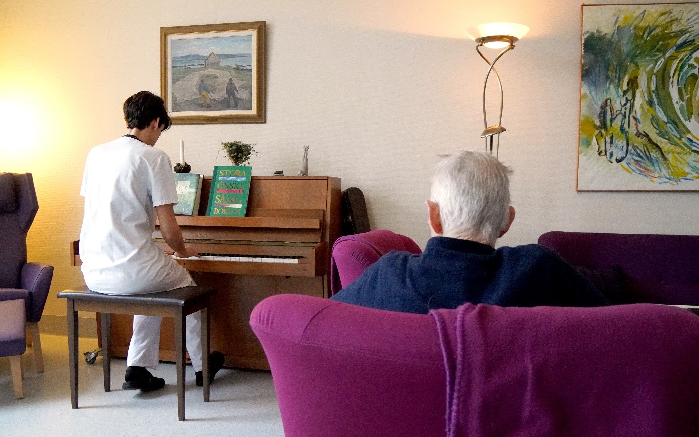 Medarbetare spelar piano i samlingsrummet. 