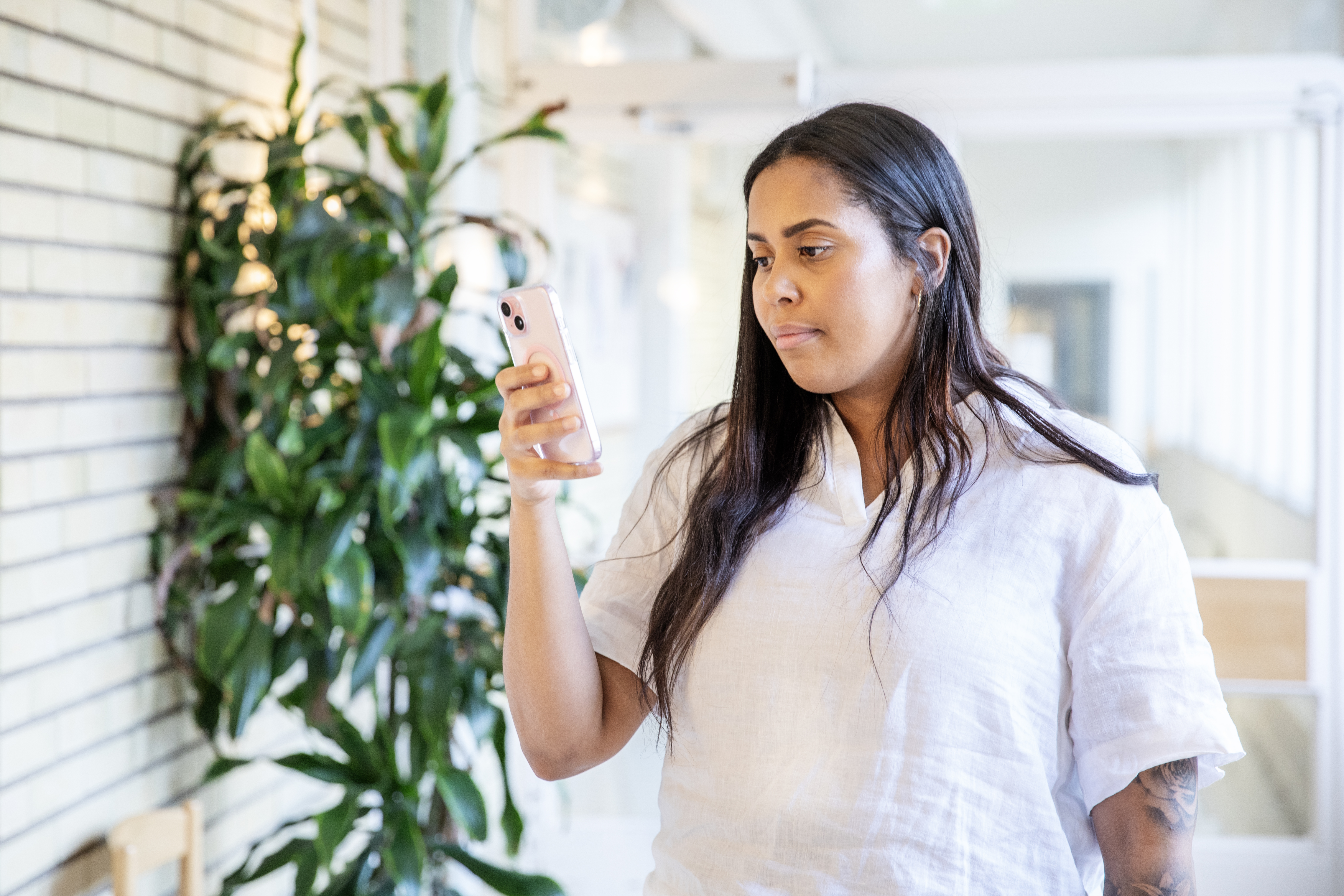 Kvinna med mobil som hon läser på.