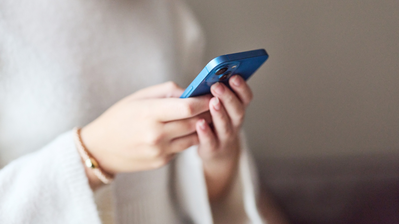 En person som håller i en mobiltelefon