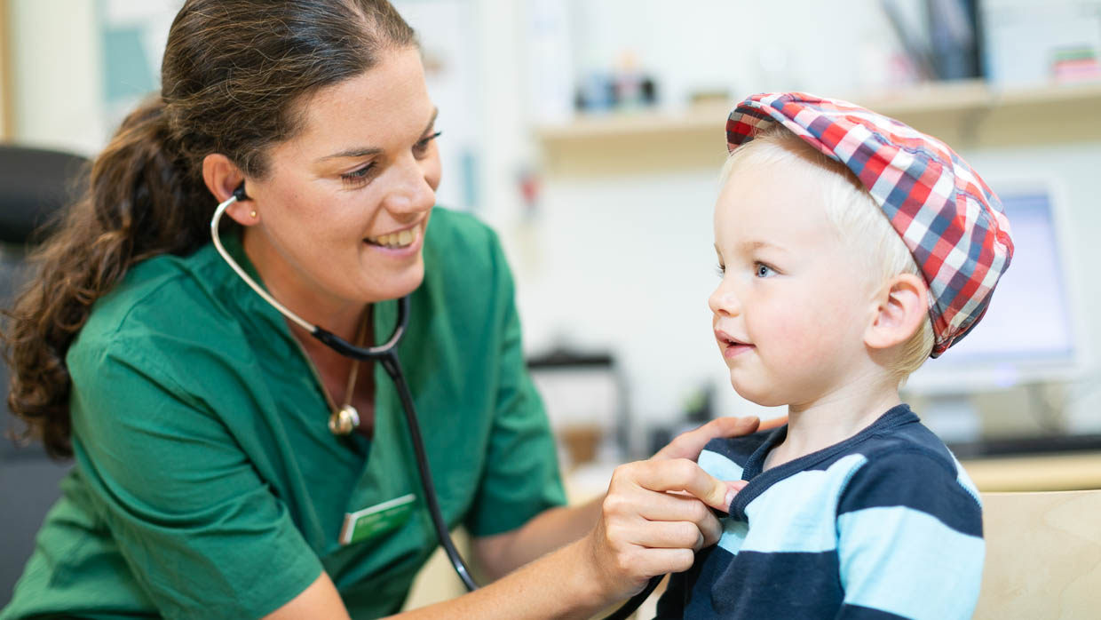 Barnhälsovårdssjuksköterska lyssnar på hjärtat med ett stetoskop på ett barn.