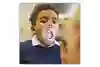 Ett barn gapar och man lyser i munnen med en ficklampa