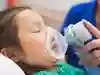 Ett barn som ligger och blundar får syrgas via en mask.