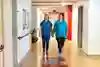 Två personer går i en korridor på ett sjukhus.
