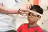 Vårdperson mäter huvudet med ett måttband på ett barn.
