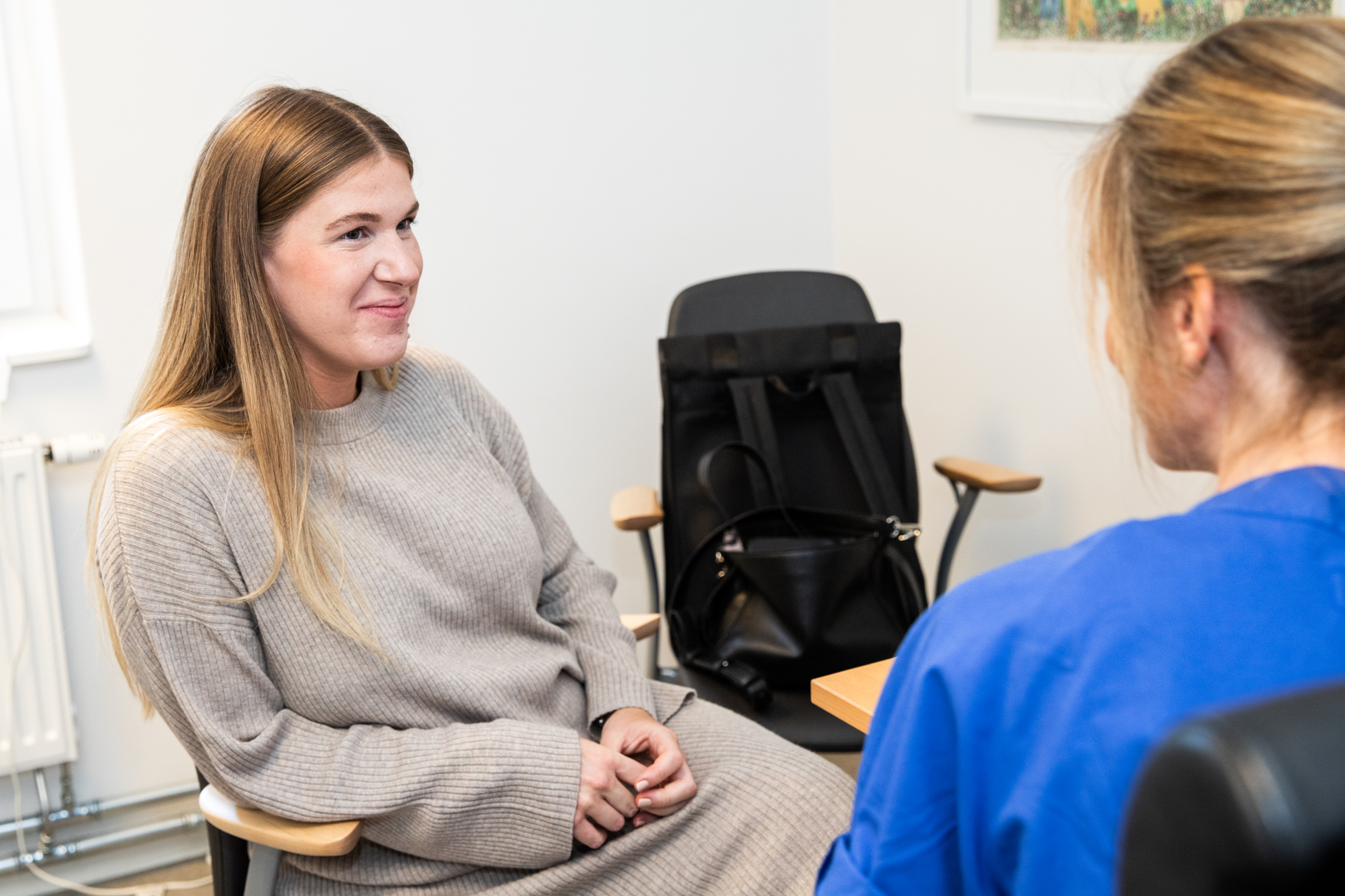 En person som sitter och pratar med en vårdpersonal.