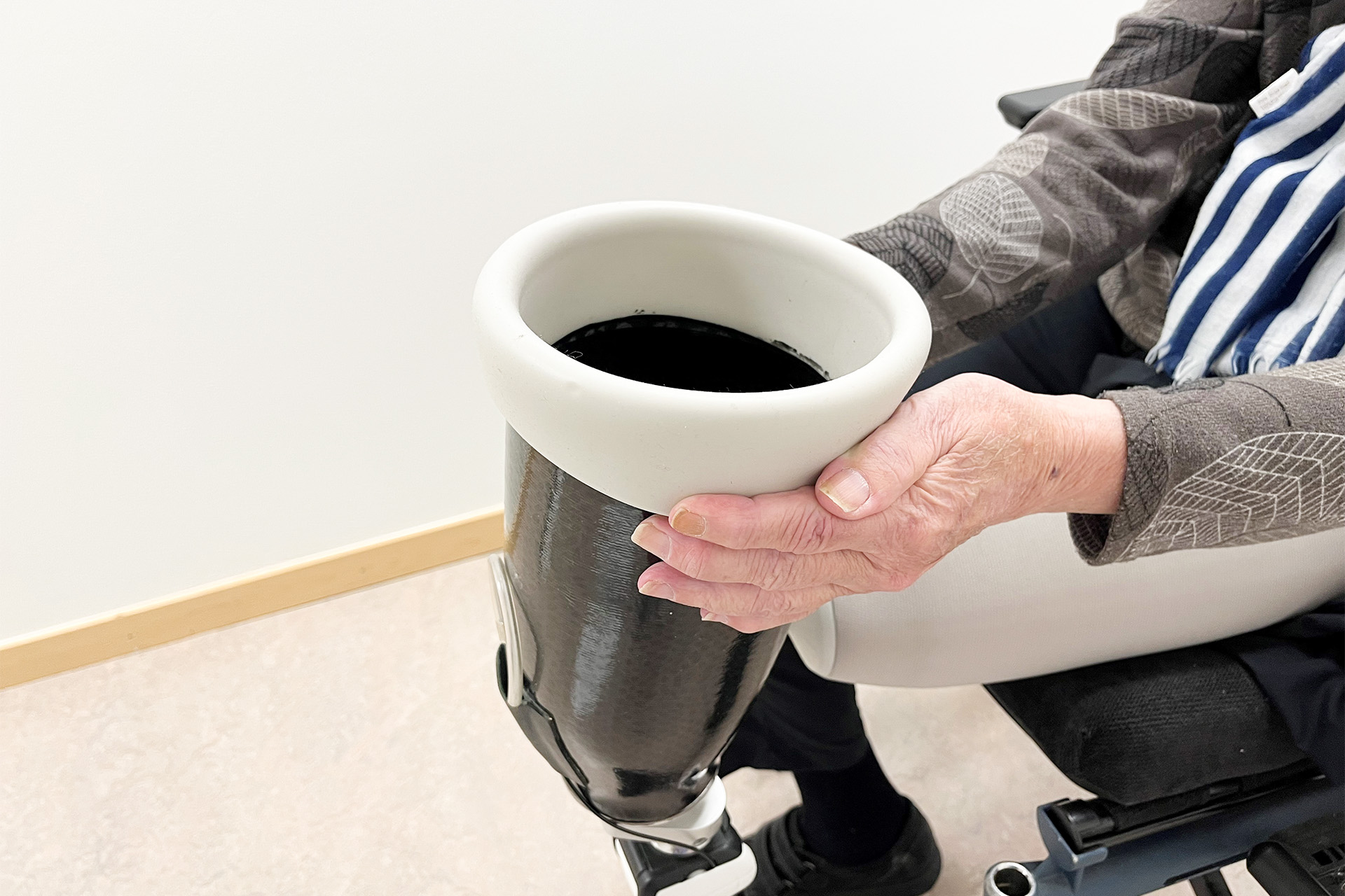 Bild på en person som håller benprotesen framför sig.