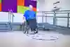 Person i rullstol som rullar över rockringar på golvet