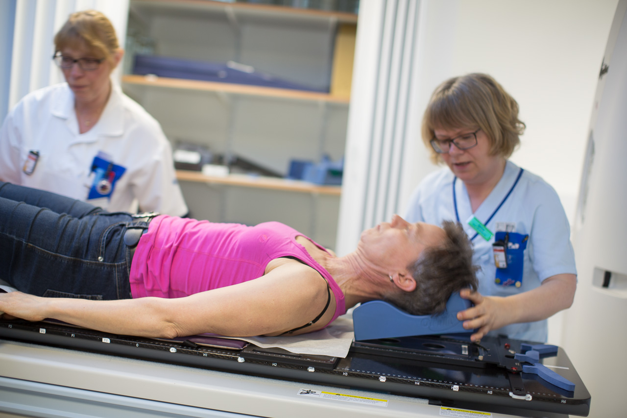 En vårdperson markerar med en penna på en patients bröstkorg. Patienten ligger på en brist.