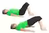 En person ligger på rygg och böjer benen med knäna uppåt. Sedan lyfter personen bäckenet uppåt.