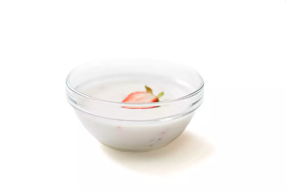 En skål med yoghurt och jordgubbar.