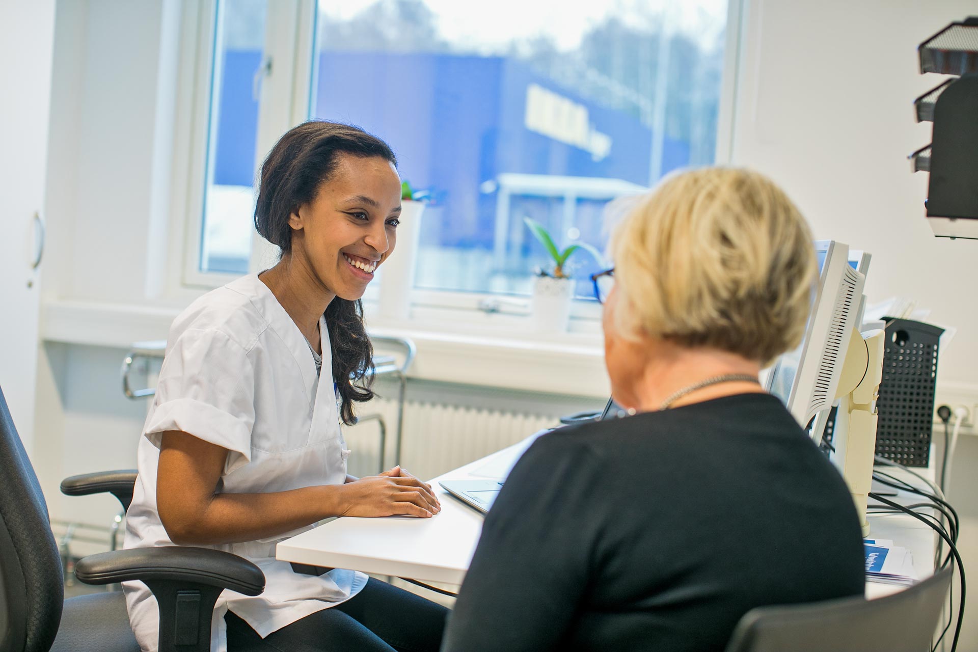Patient och personal sitter och pratar med varandra under ett hälsosamtal