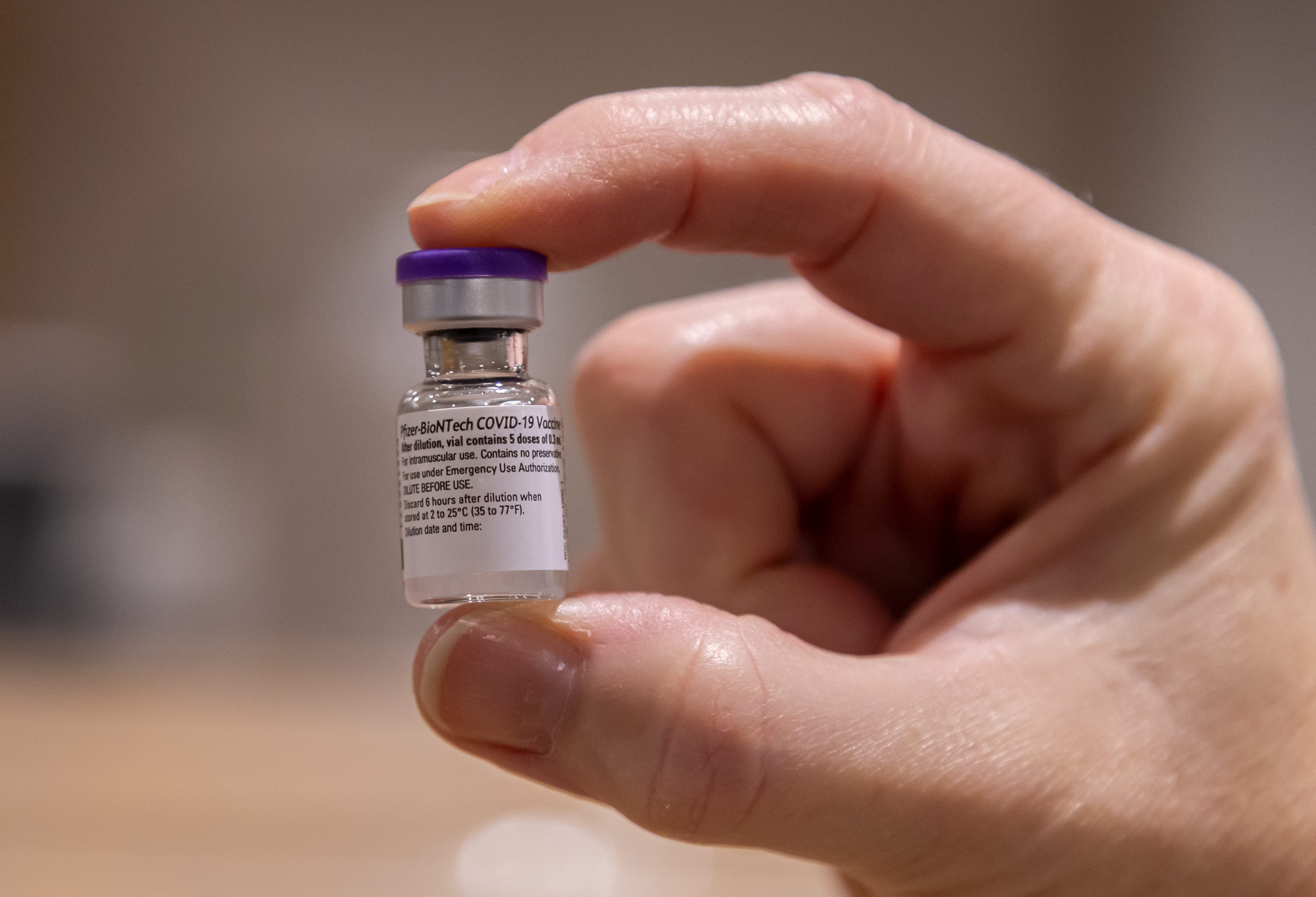 Hand som håller i en ampull med vaccin mot covid-19