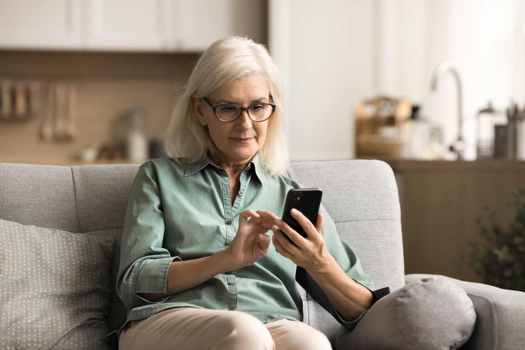 Person som sitter med mobil och tittar på  sidan 1177 e-tjänster i inloggat läge.