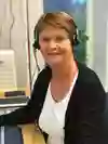 sjuksköterska har ett head-set på sig och pratar i telefon