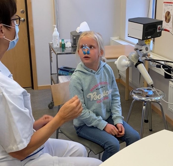 Flicka med näsklämma på näsan