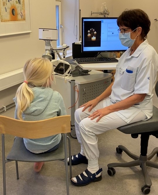 Flicka blåser i en apparat