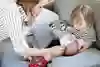 Litet barn sitter i soffa med bebis i knät.