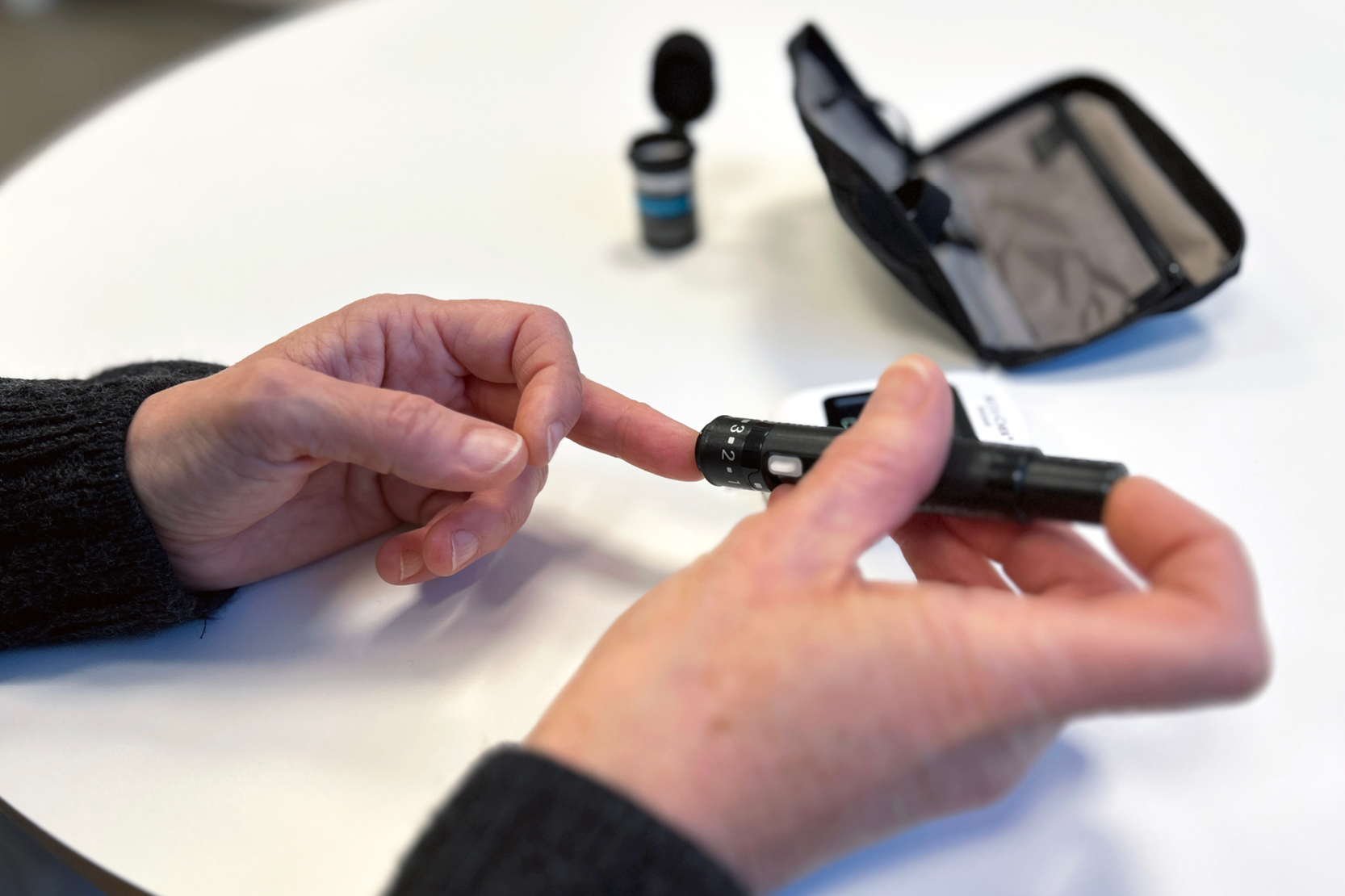 Detaljbild på en person som testar sitt blodsocker genom ett stick i fingret.