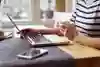 Person med dator vid köksbordet.