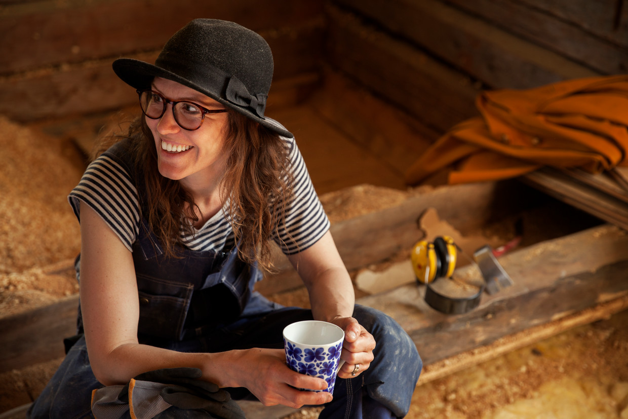 En kvinna som renoverar tar en paus med en kopp kaffe.