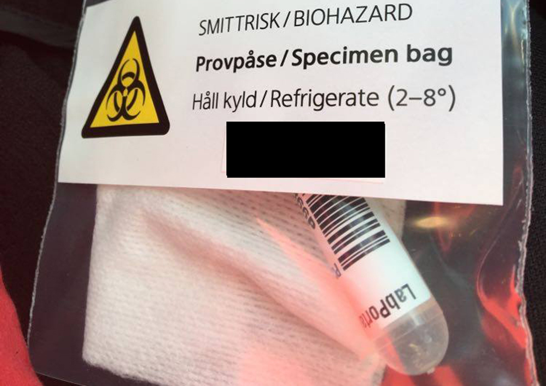 Provtagningskit i en plastpåse med etikett med texten Smittrisk/Biohazard, Provpåse/Specimen bag, håll kyld (2-8 grader)
