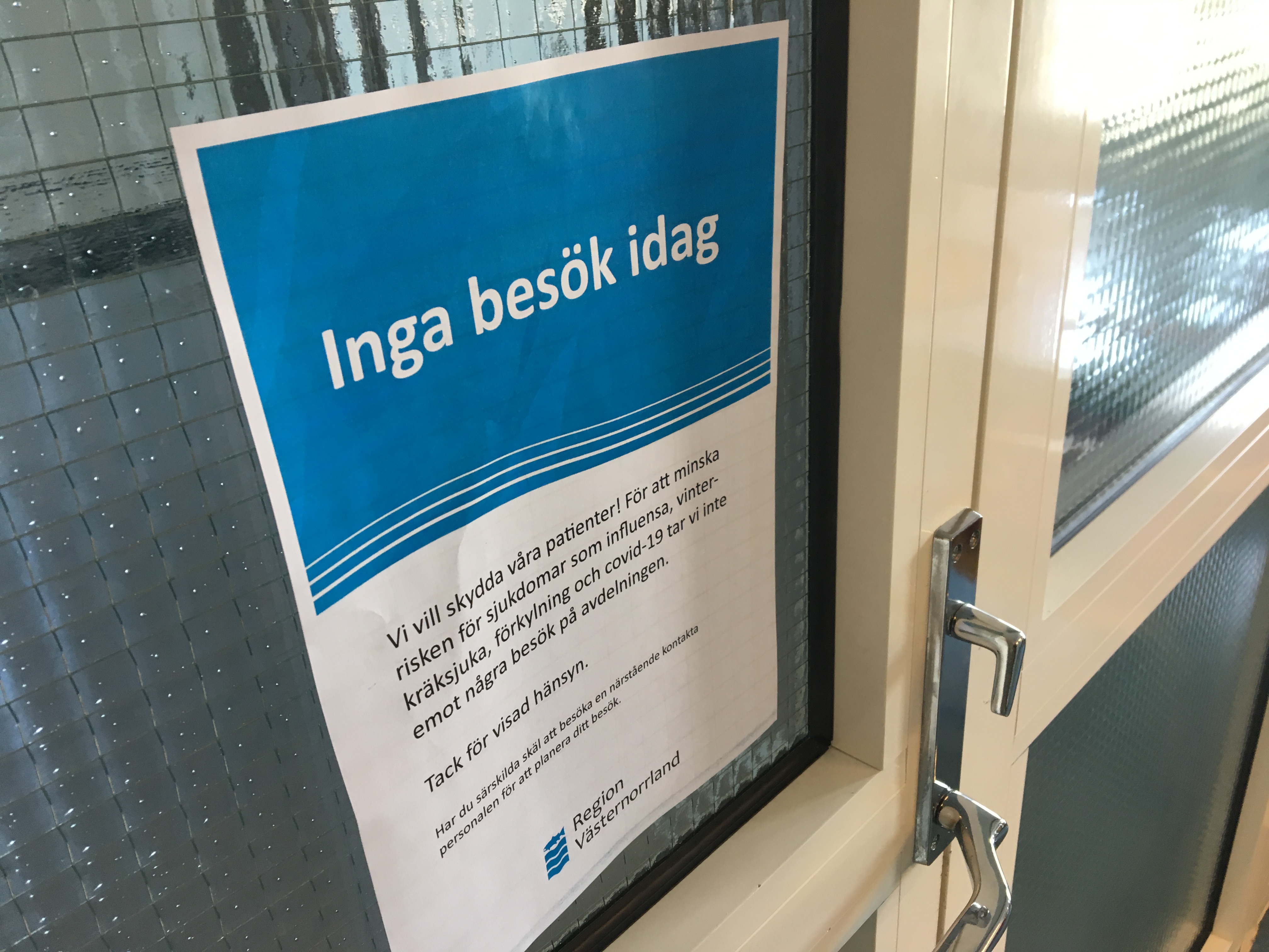 Affisch utanför sjukhusdörr med information om besöksförbud