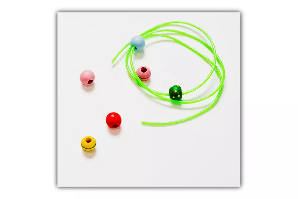 Pärlor och tråd som används vid kontroller i barnhälsovården.