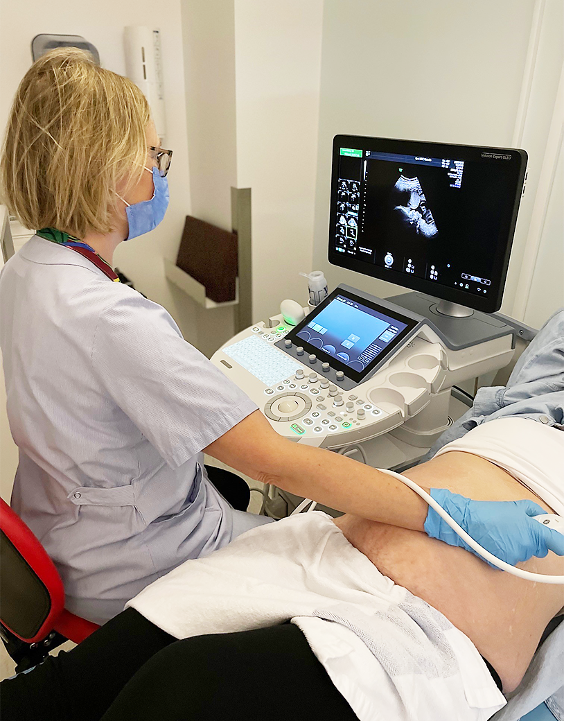 Barnmorskan utförs ultraljud på den gravidas mage