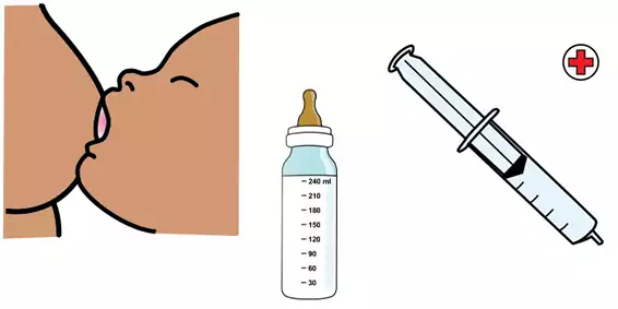 En baby som ammas, en vällingflaska och en spruta för sockerlösning